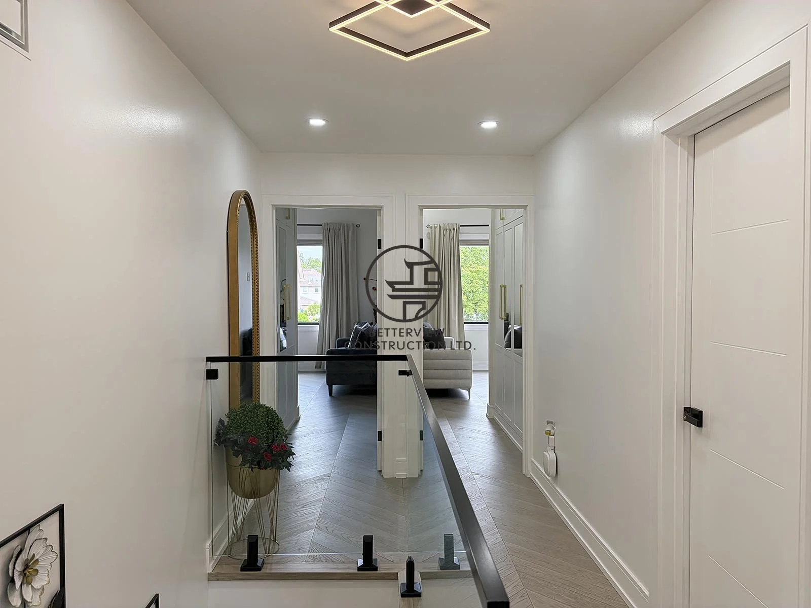 The second-floor landing showcases sleek glass railings, modern lighting, and minimalist design elements that complement the home's contemporary interior.
