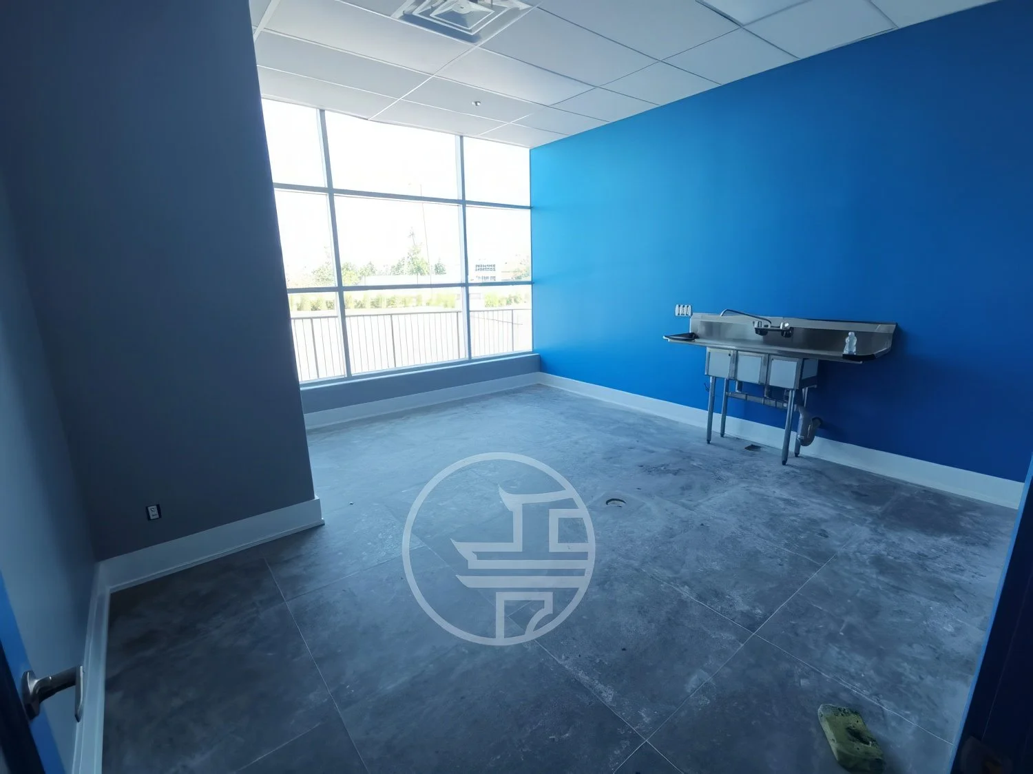 Commercial interior space preparation in Toronto featuring open layout, concrete flooring, and utility sink before final finishes