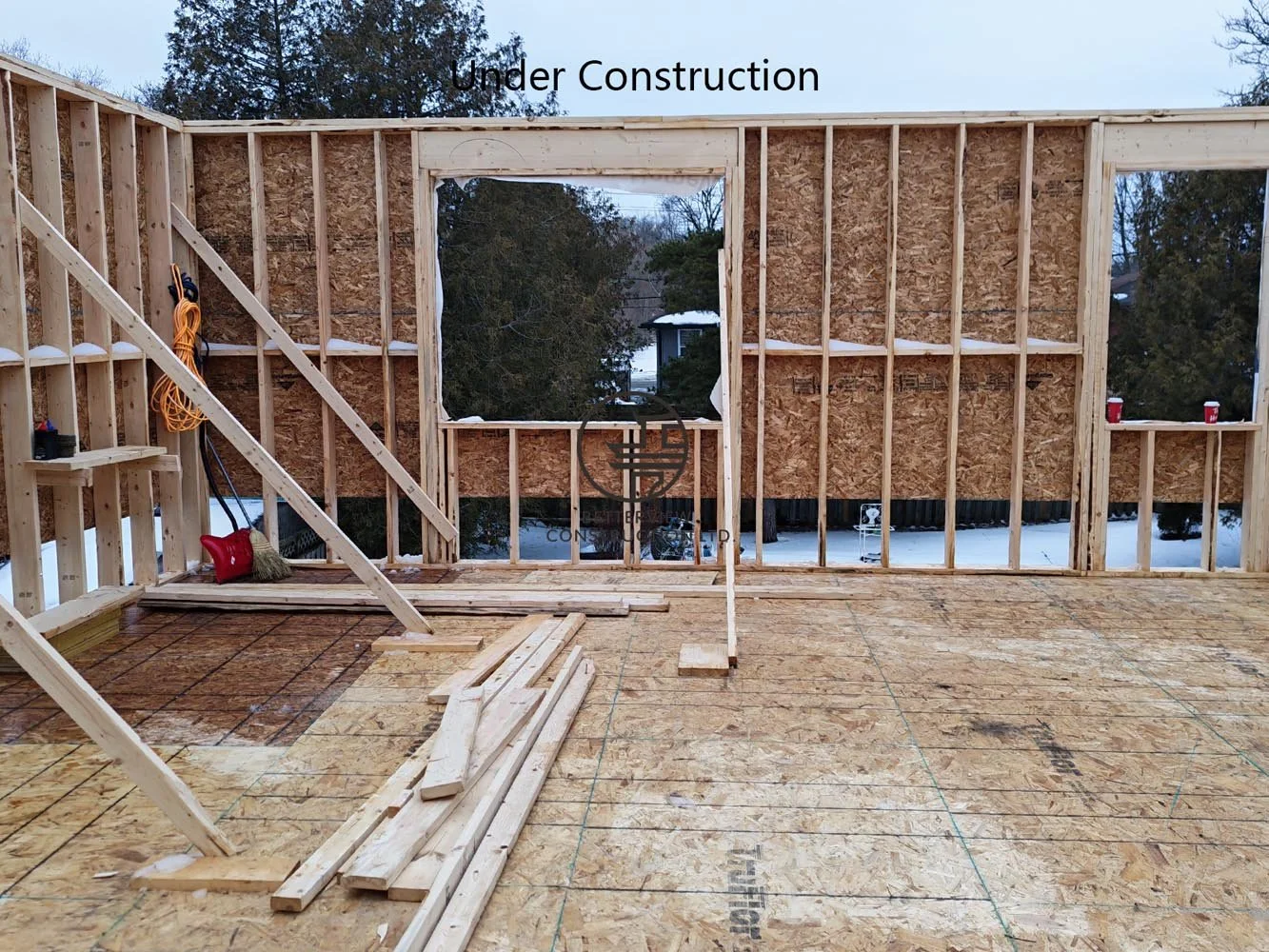 Rear home addition structural framing with large window openings, preparing for a modern open concept living space.
