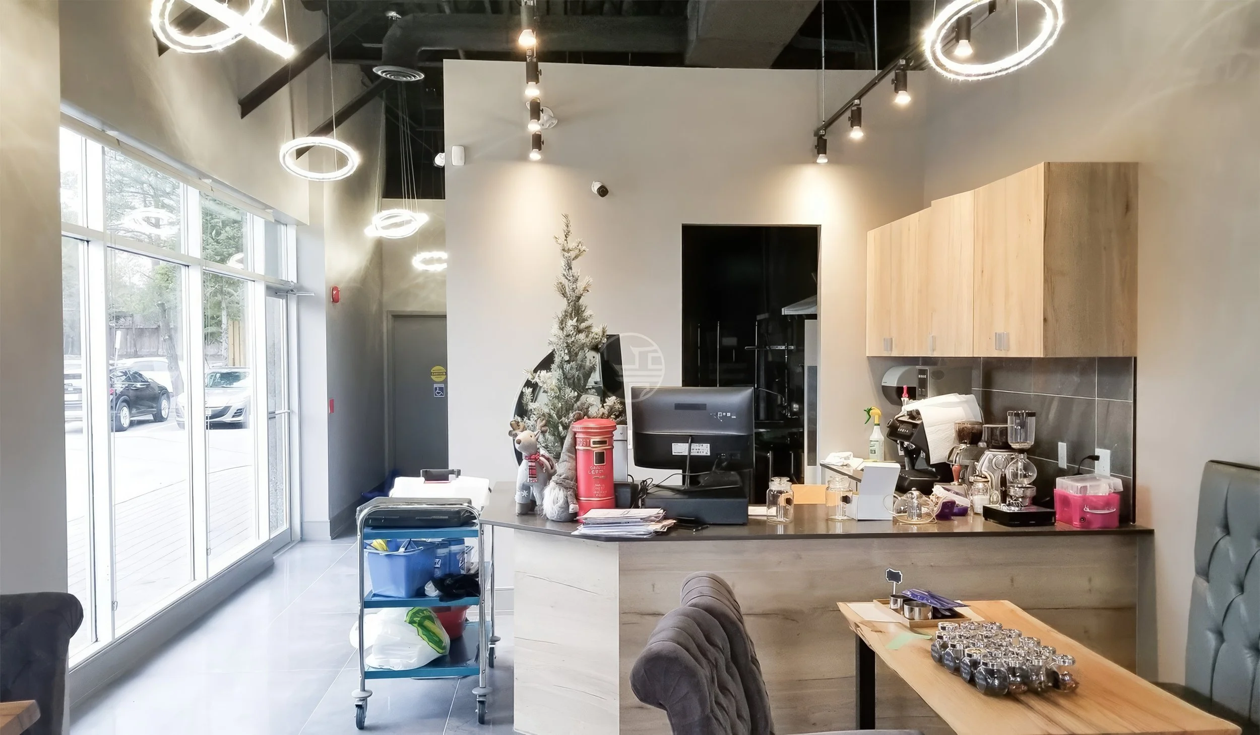 Modern cafe interior renovation in Toronto featuring coffee bar, high ceiling lighting design, and contemporary commercial space
