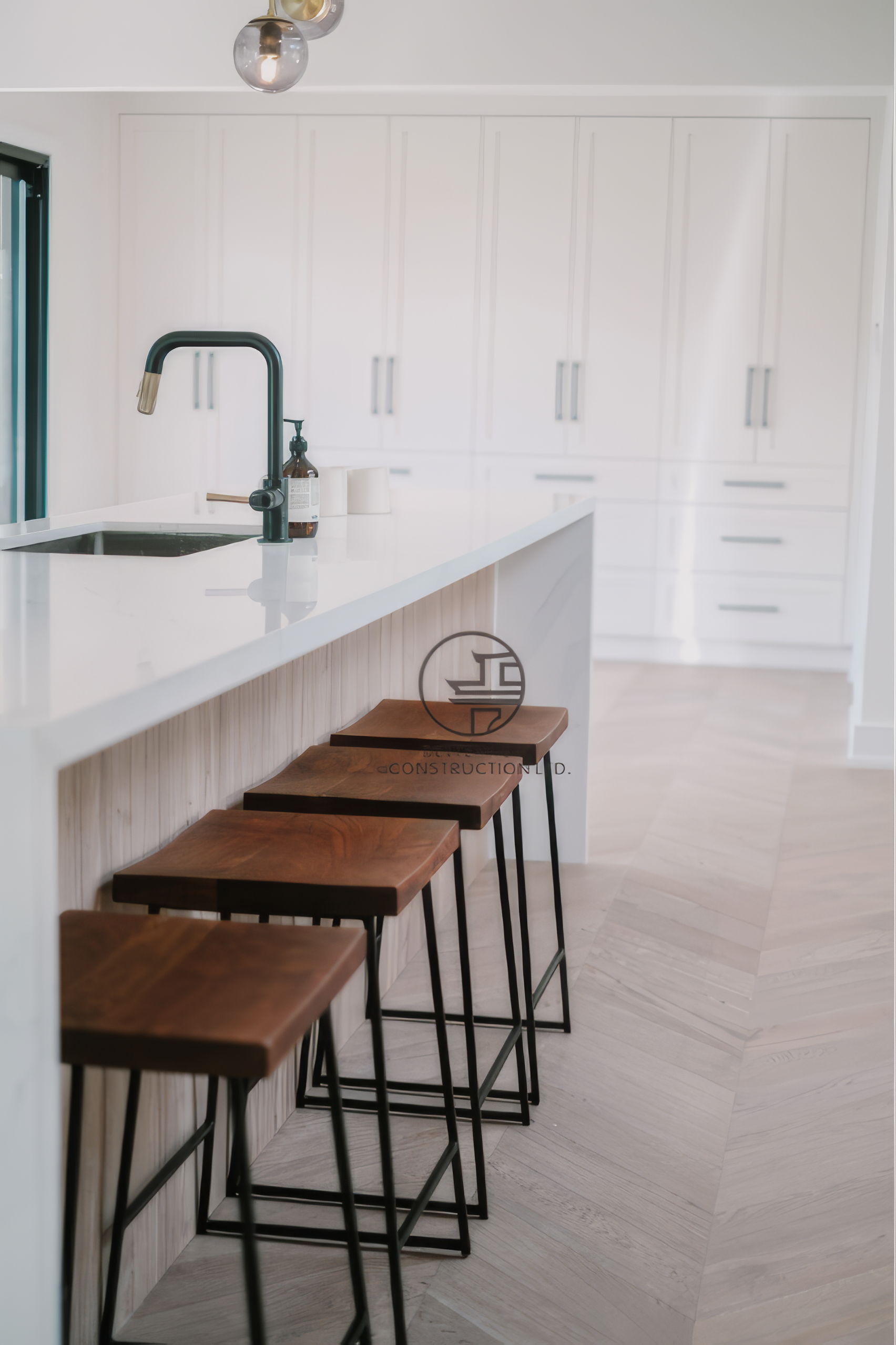 Modern kitchen renovation with large island seating, white cabinetry, and minimalist interior design in a Toronto home.