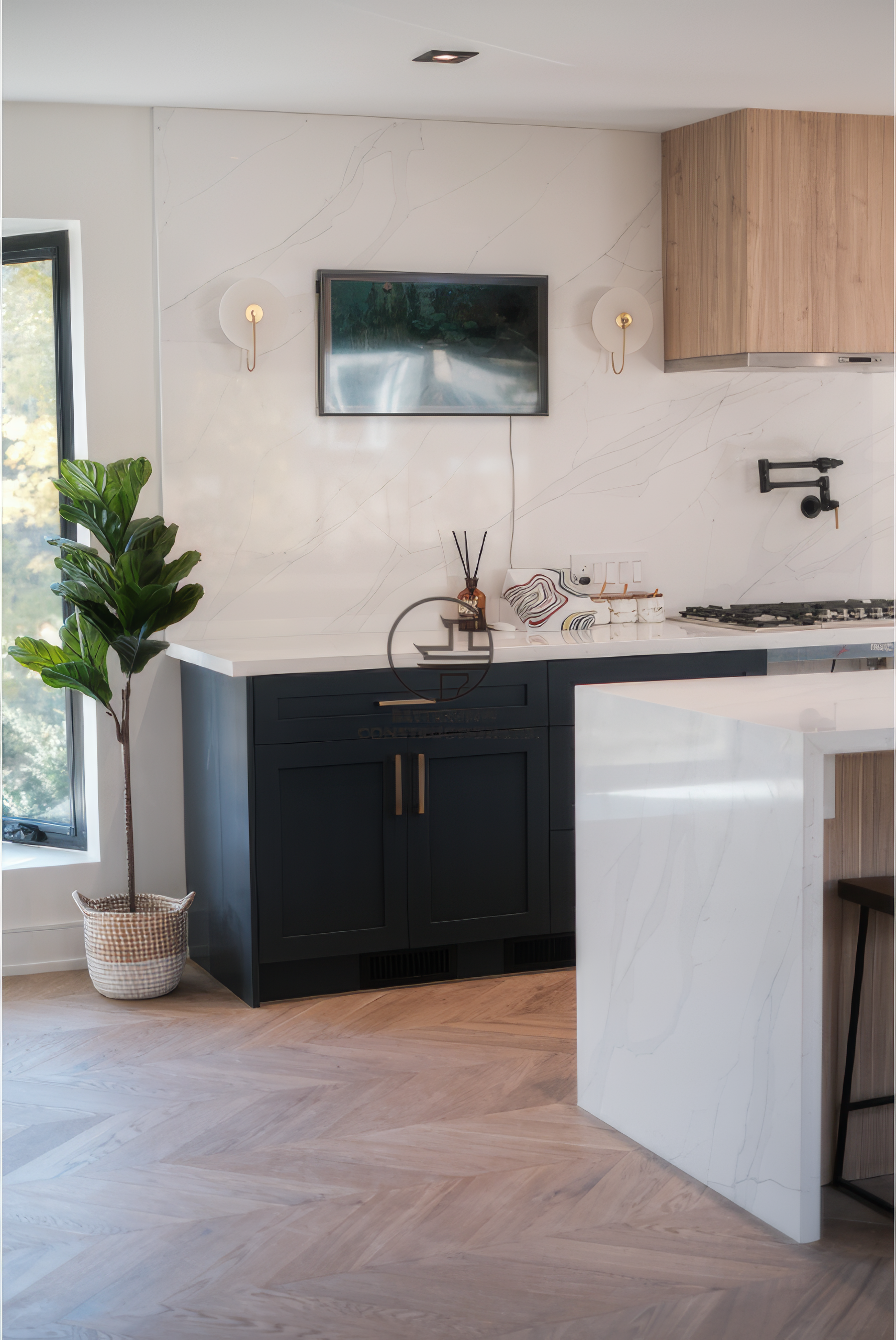 Modern kitchen renovation with white island, black cabinetry, and herringbone wood flooring in a Toronto home.