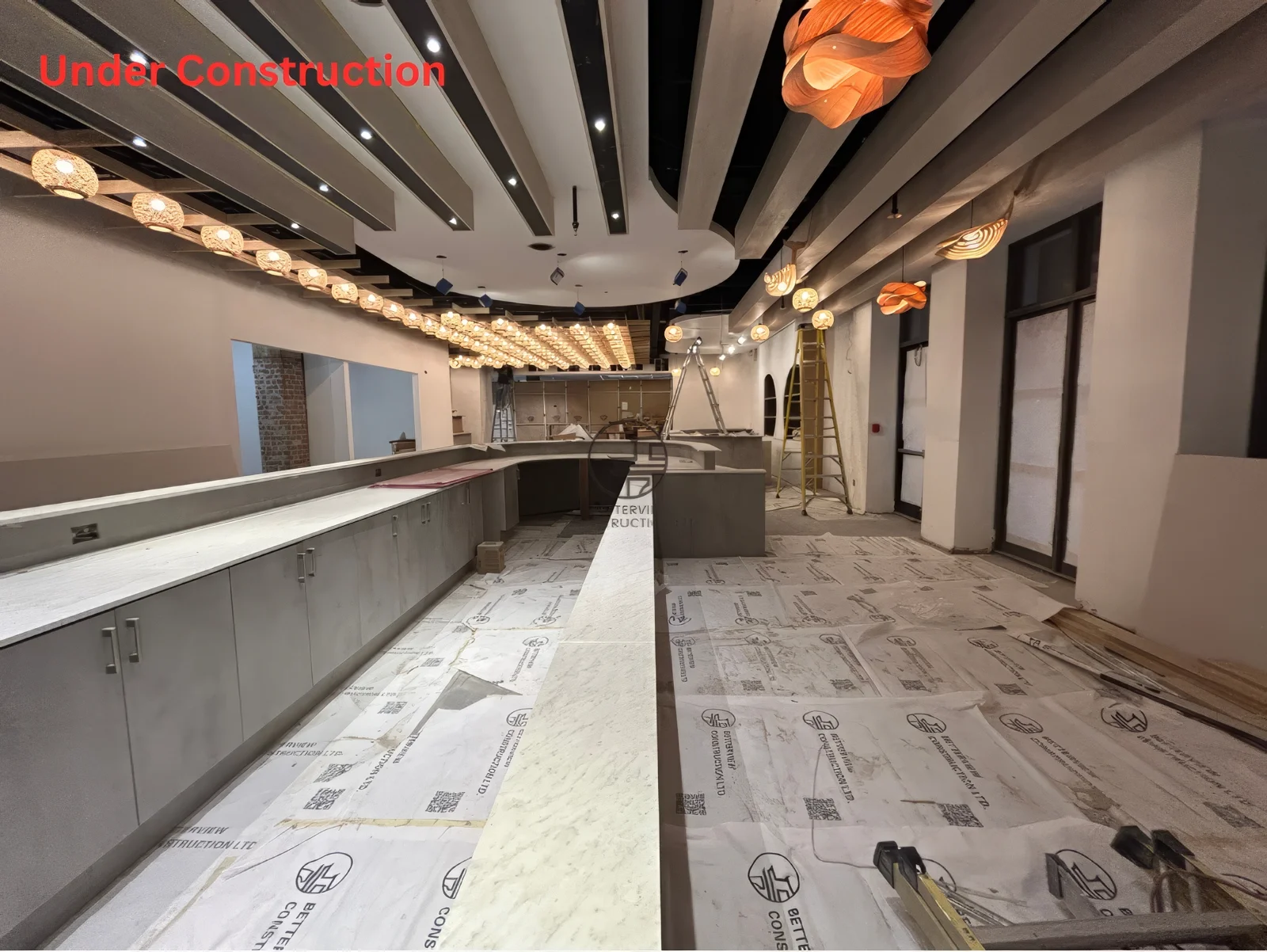Restaurant bar counter installation in Toronto with custom cabinetry, ceiling lighting fixtures, and ongoing commercial renovation work