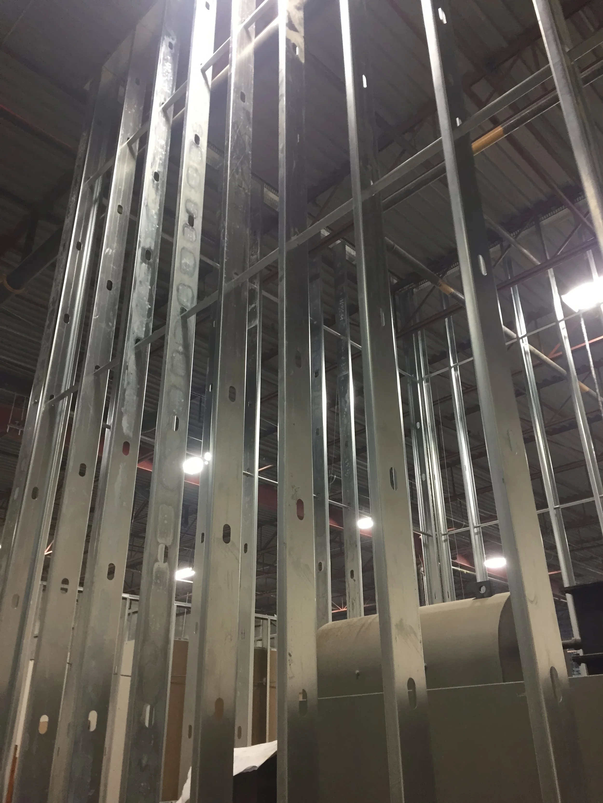 Close-up of commercial steel stud framing showing metal wall structure and vertical support system in a warehouse renovation project in Toronto