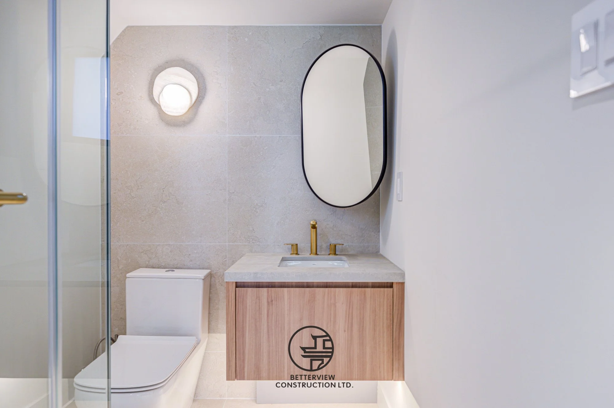 modern bathroom renovation with floating wood vanity marble countertop and gold faucet