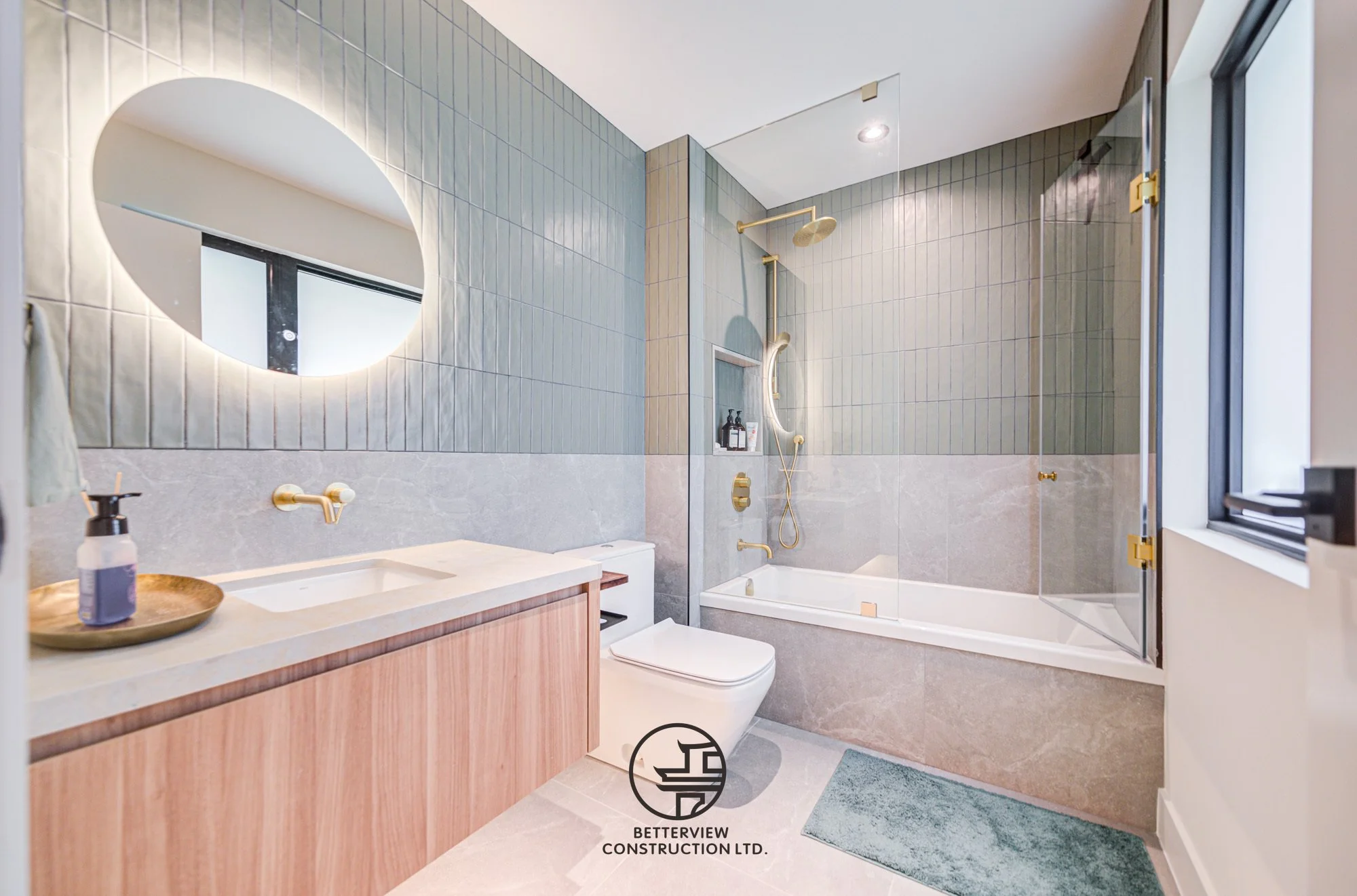 modern guest bathroom renovation with round mirror and bathtub shower
