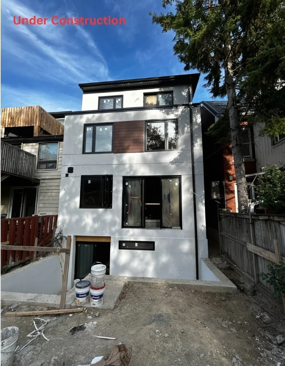 Modern custom home under construction with unfinished landscaping, contemporary exterior design, and multi-level structure in residential build project.