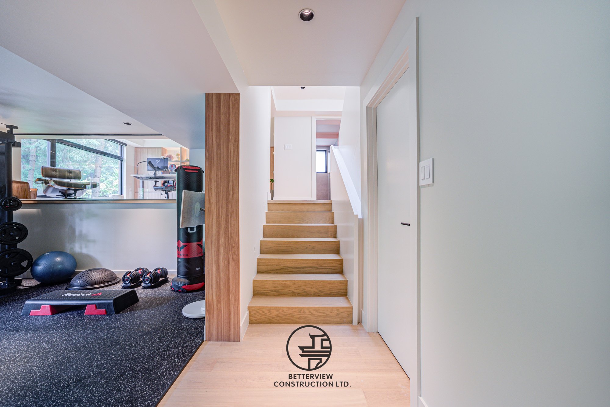 modern basement renovation with wood staircase and home gym space
