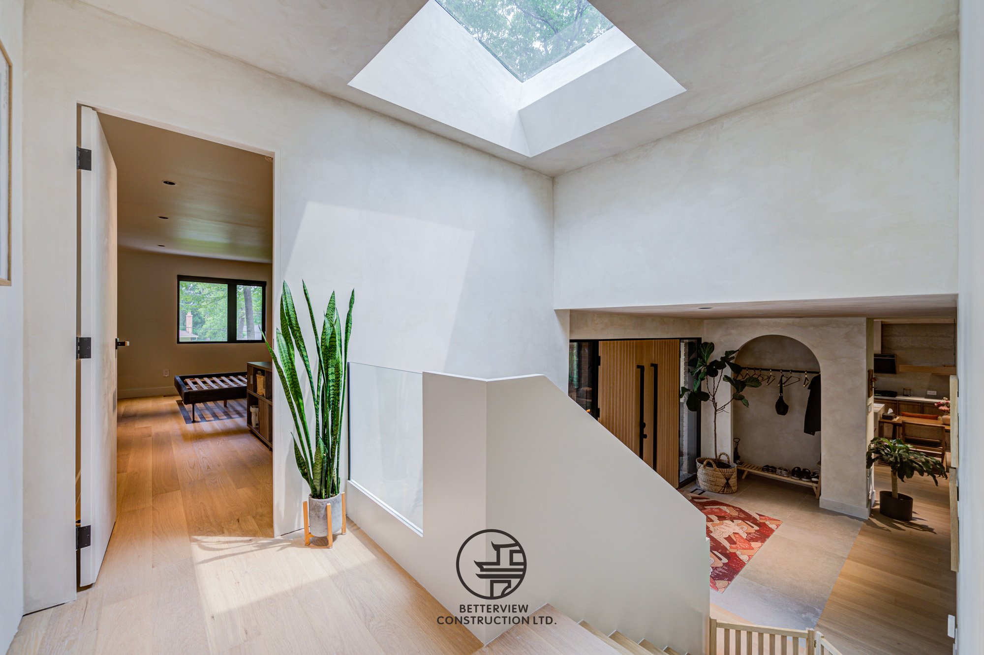 modern staircase landing with skylight bringing natural light into renovated home