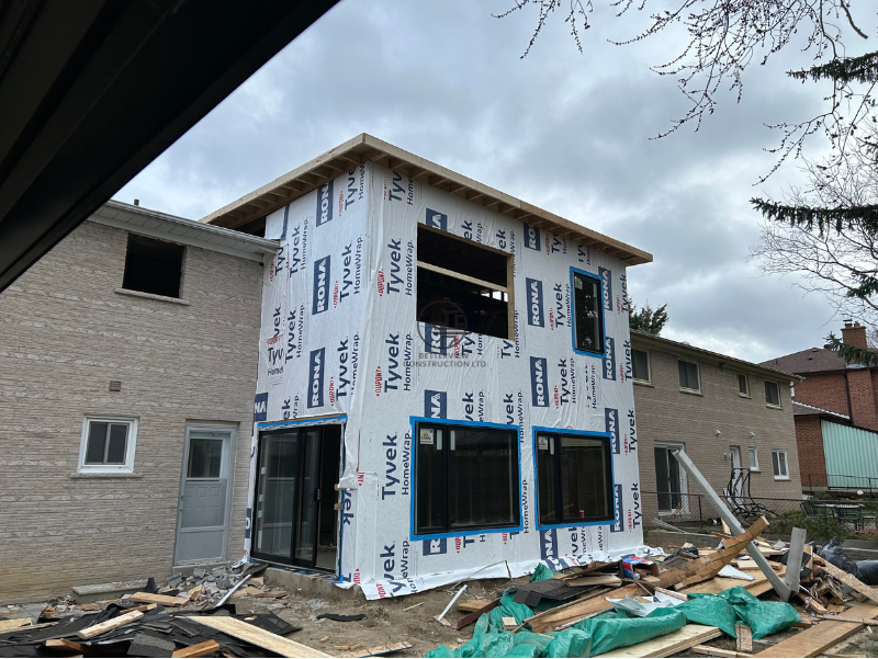 Exterior view of a home addition under construction with Tyvek house wrap and new window installation in progress in the GTA