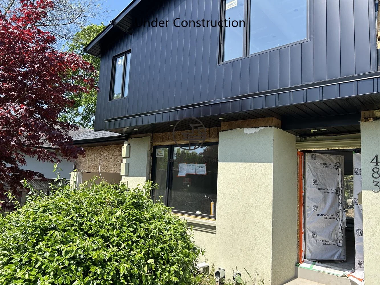 Exterior view of a completed second floor addition featuring modern black siding and expanded living space for a residential renovation.