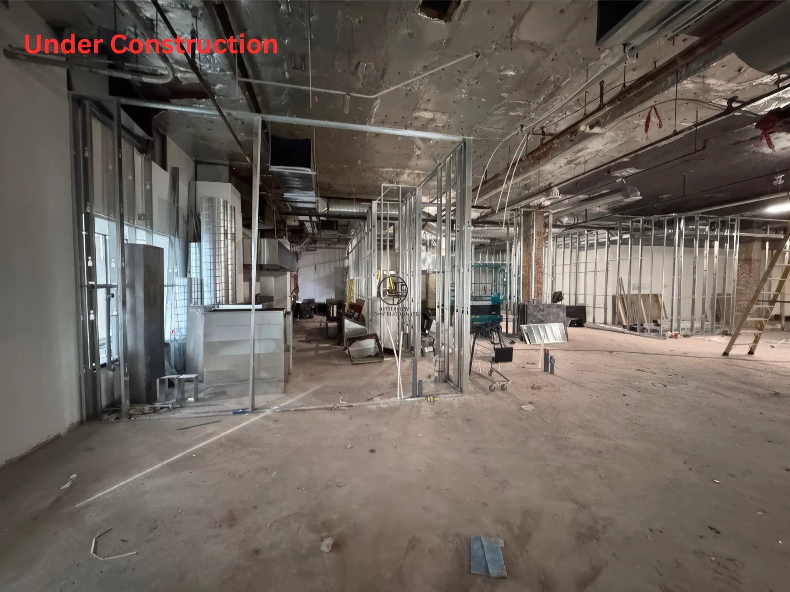 Commercial restaurant construction in Toronto showing metal framing, HVAC ductwork, and early-stage renovation process