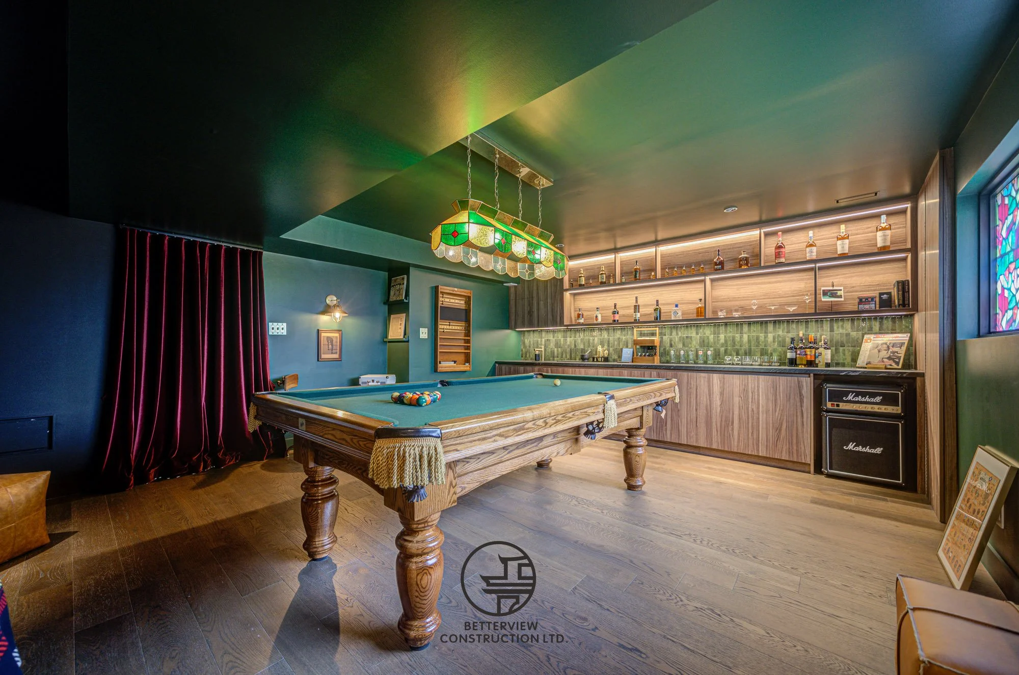 modern basement renovation with billiards table and built in bar area
