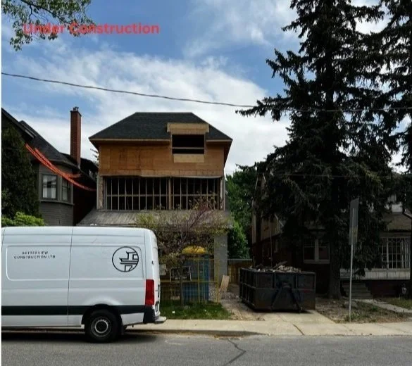 Exterior view of a home addition under construction showing structural framing and second-storey work in progress in the GTA