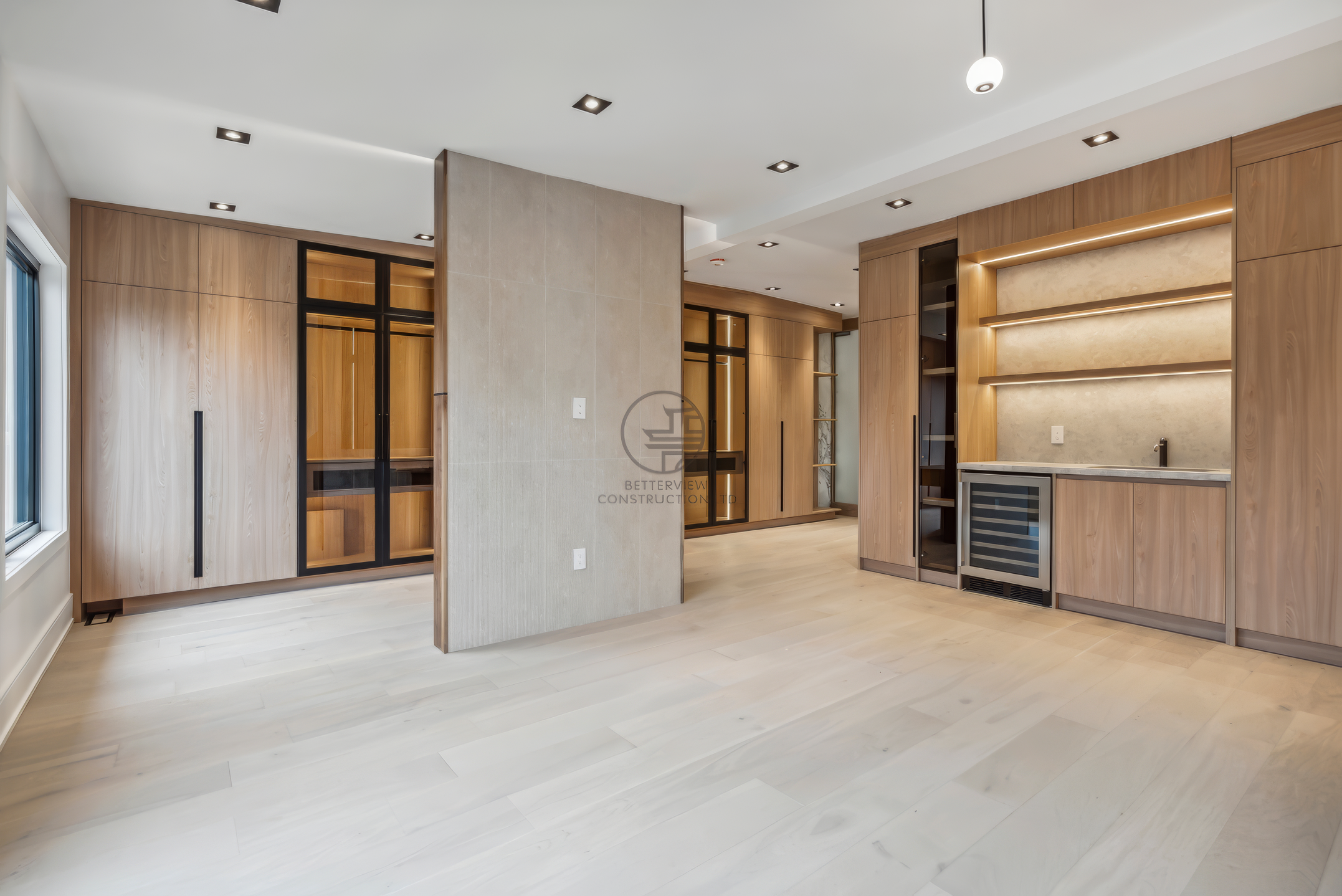 Modern finished interior with custom wood cabinetry, built-in shelving, recessed lighting, and open-concept living space in a luxury home renovation project