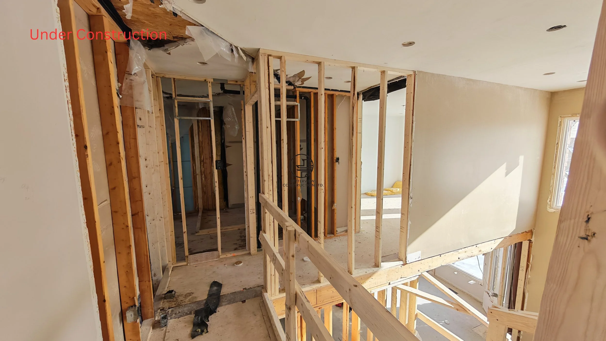 home renovation framing stage with exposed studs stair opening and structural layout changes in residential remodeling project