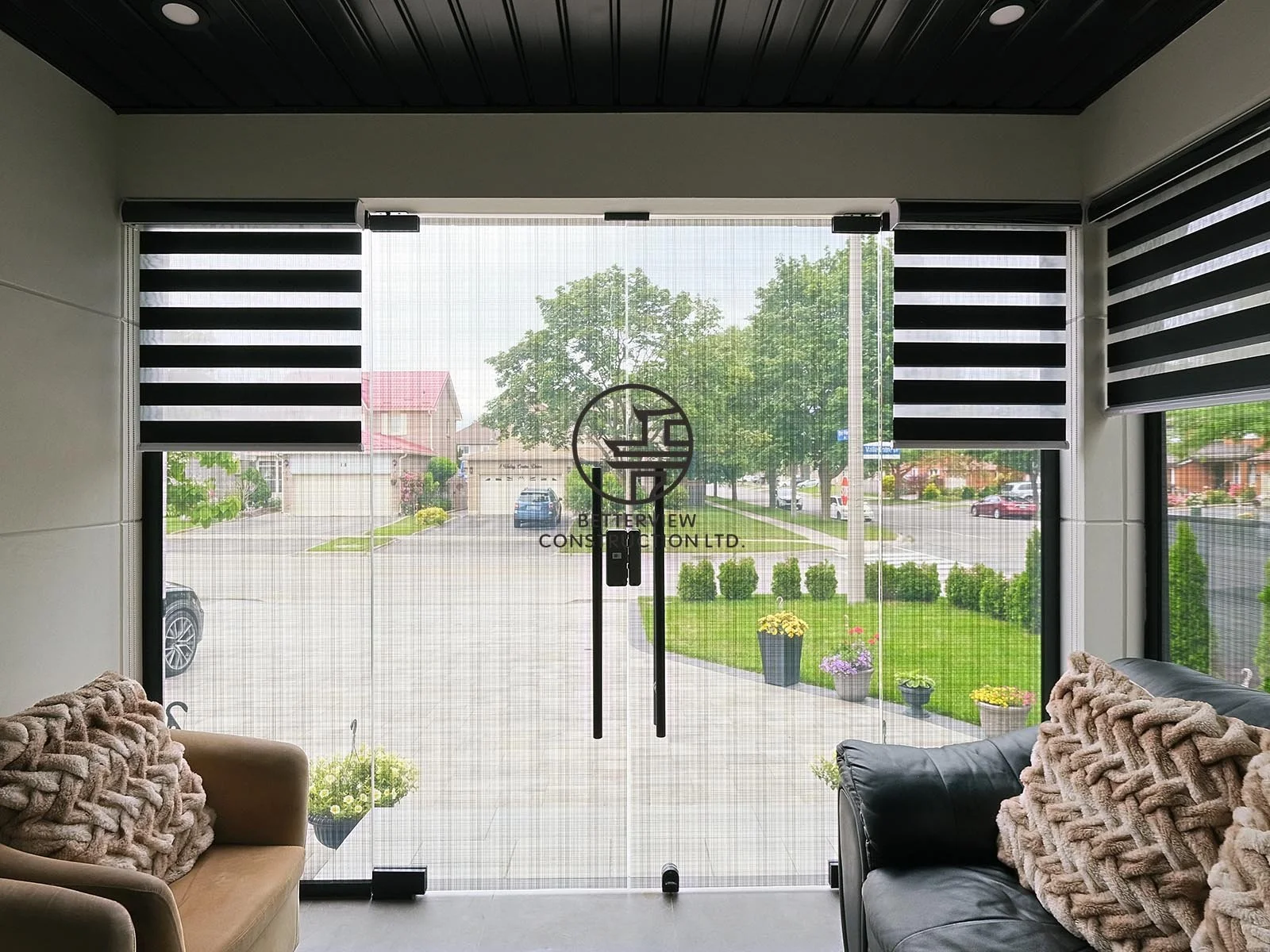 The entrance of the home addition features full-height glass doors, modern zebra blinds, and bright natural light, creating an open and welcoming transition into the expanded living space.