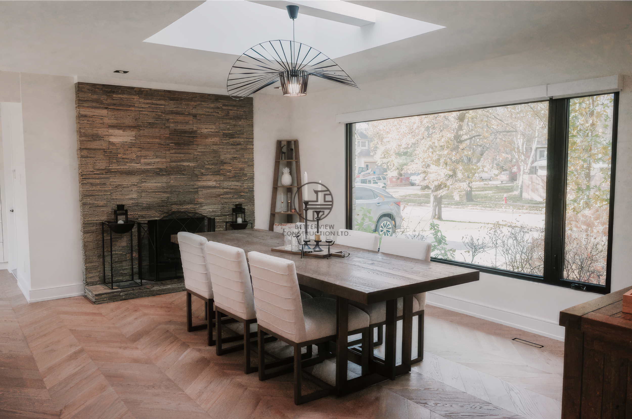 Modern dining room renovation with skylight ceiling, large picture window, and wood dining table in a Toronto home.