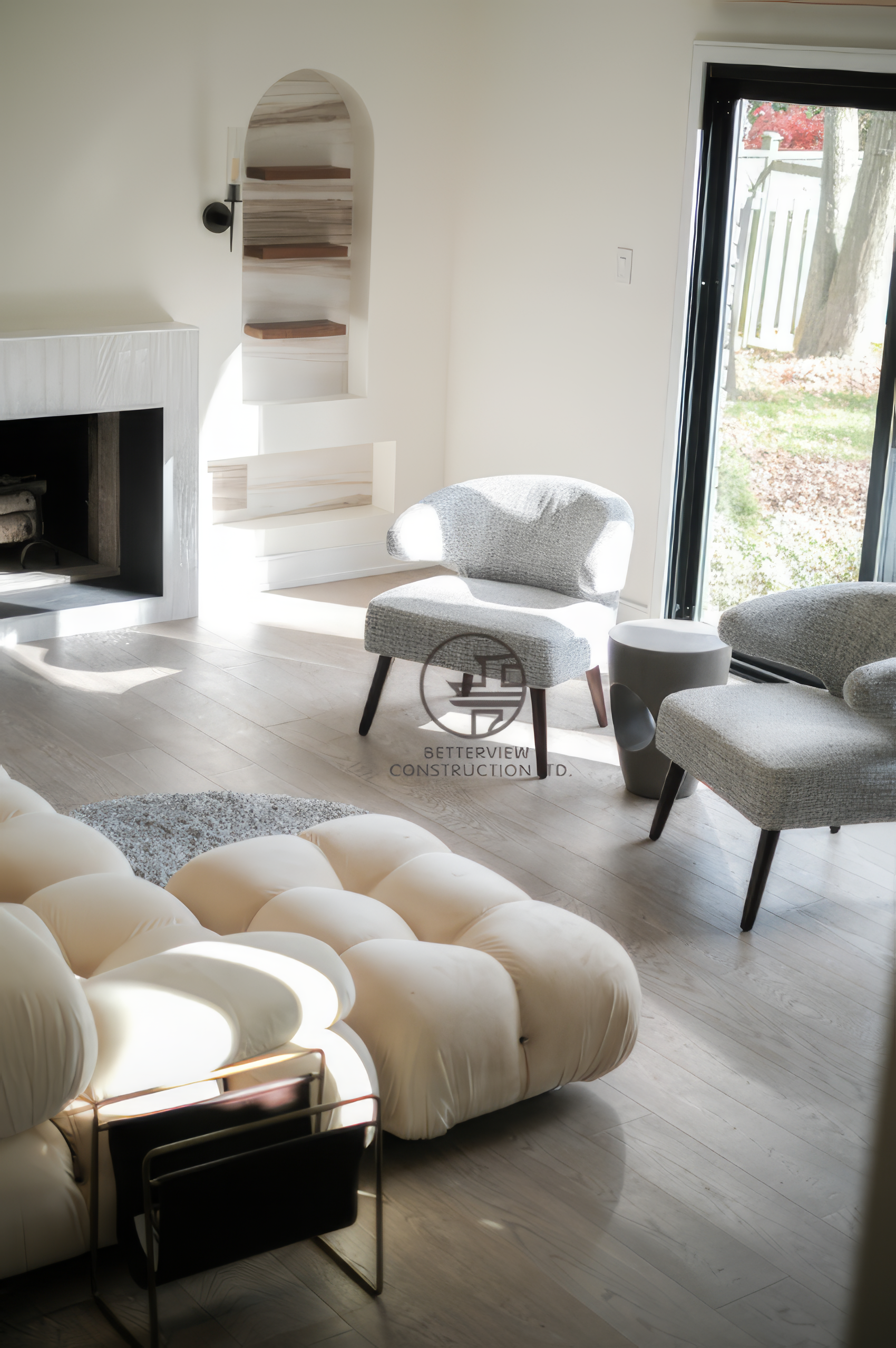 Modern living room renovation with fireplace wall, built-in shelving niche, and cozy seating area in a Toronto home.