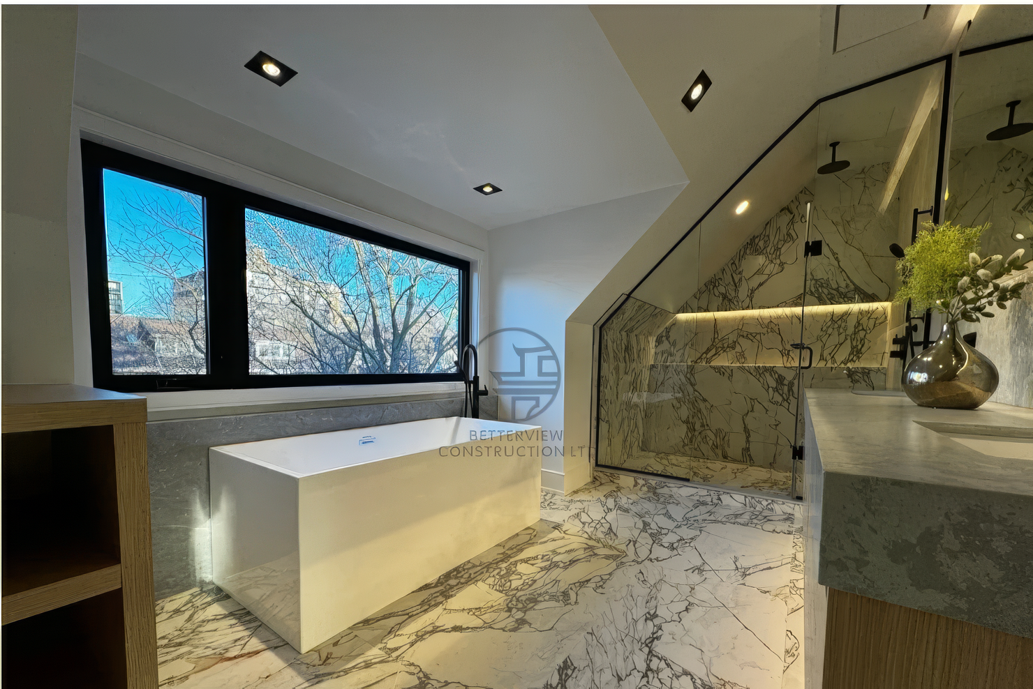 Modern bathroom with freestanding bathtub, marble tile flooring and walls, glass walk-in shower, and large window in a luxury home renovation project