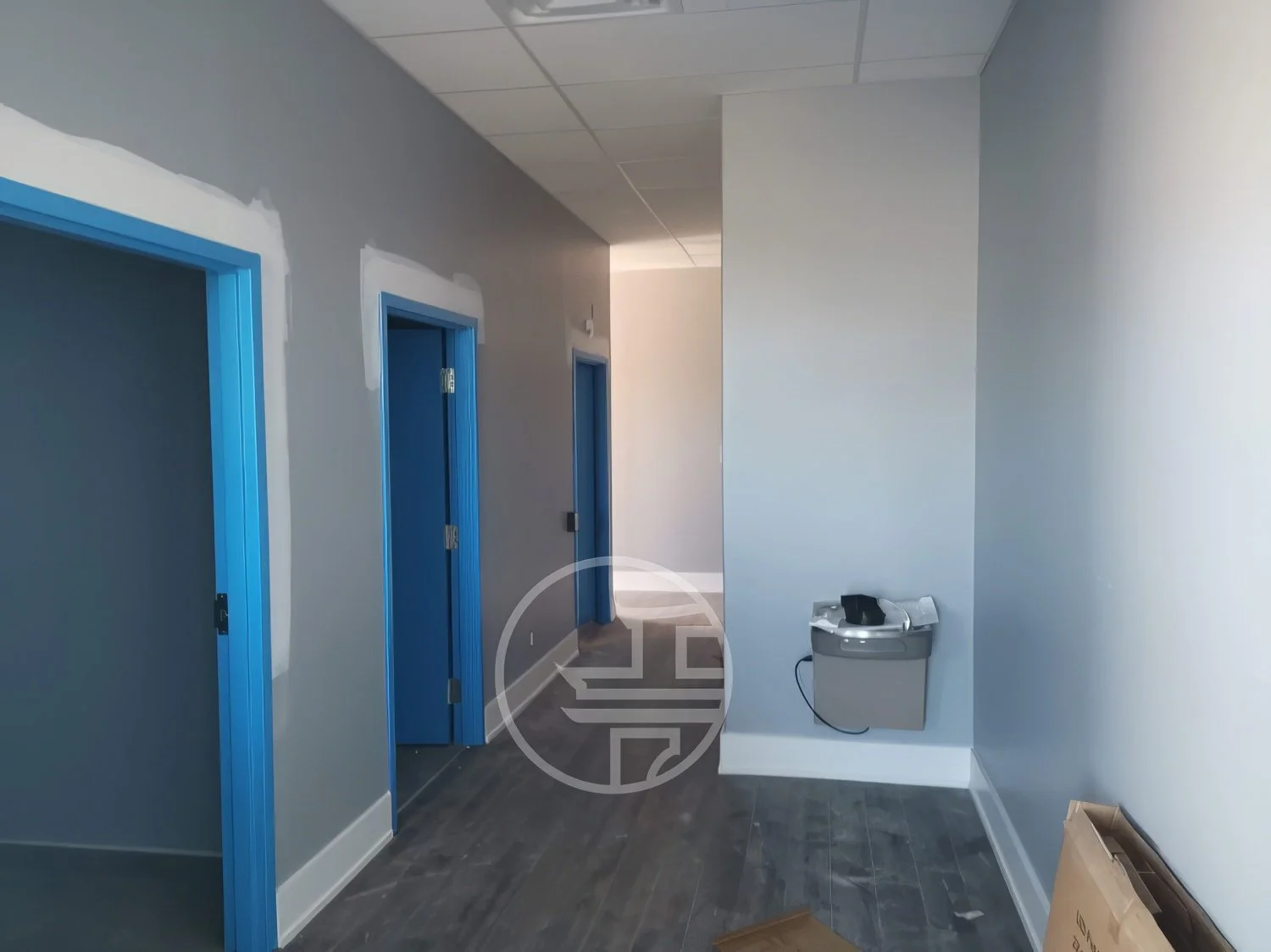 Commercial office interior finishing with hallway, newly installed doors, trim work, and flooring during renovation in Toronto