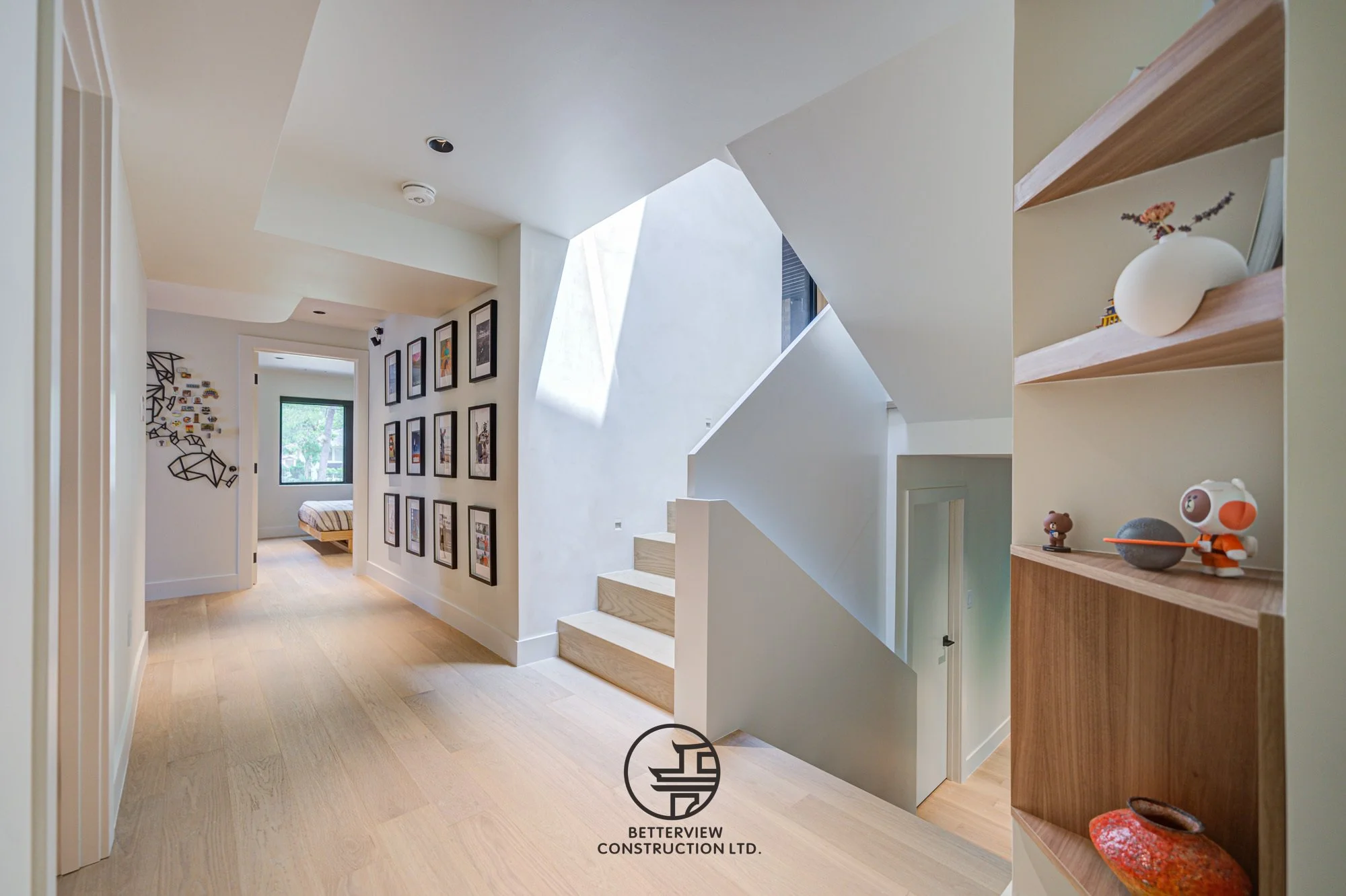 modern hallway with staircase and skylight