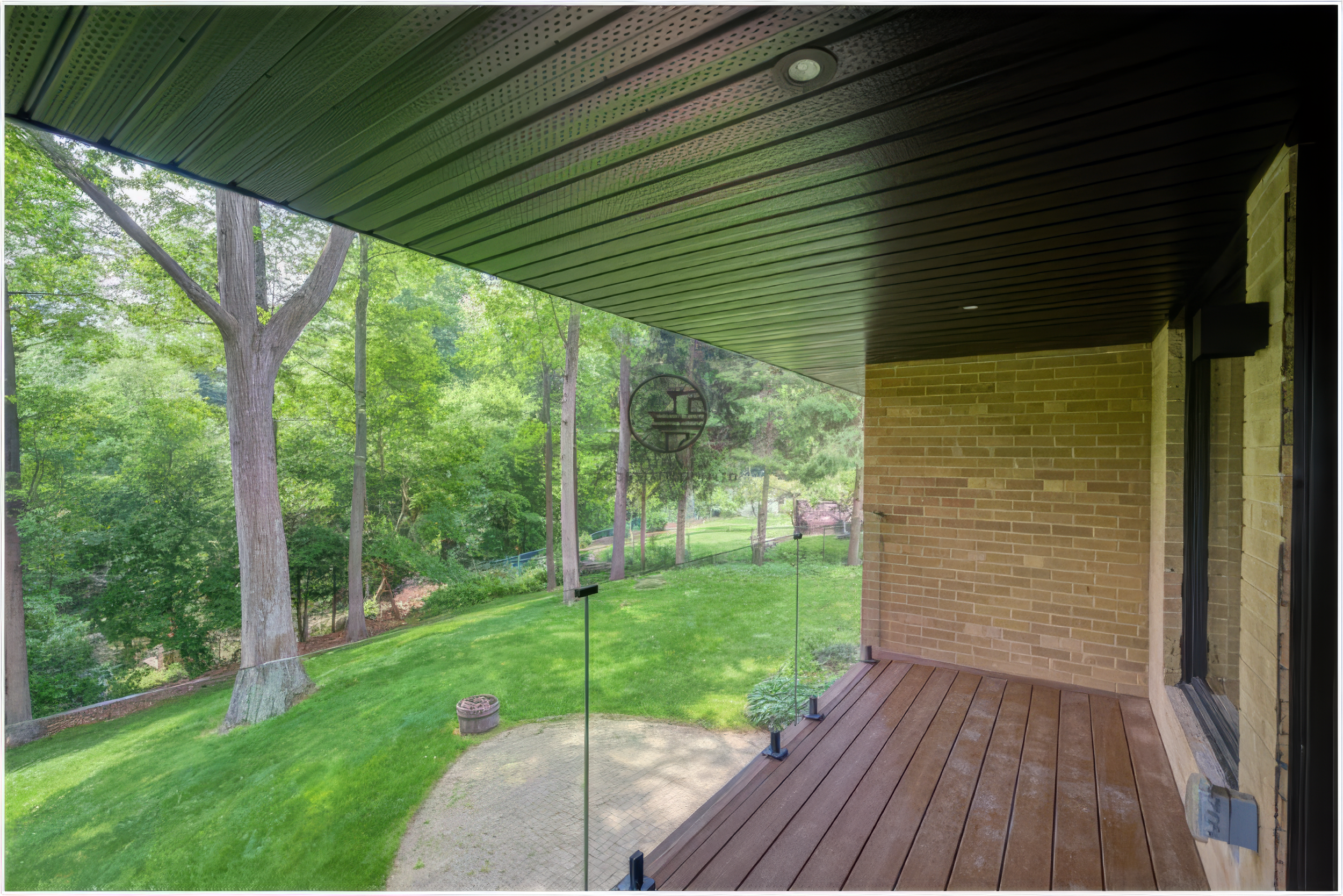 modern backyard deck with glass railing and garden view