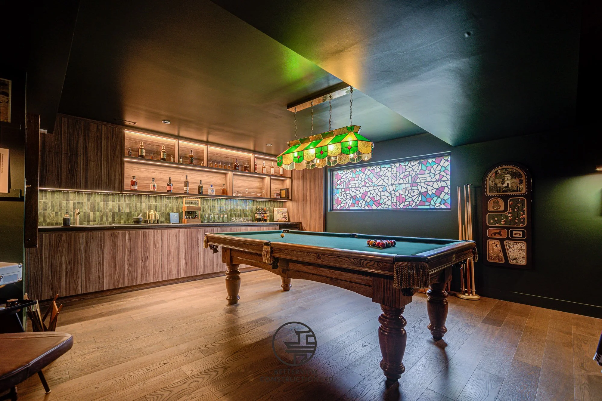 modern basement renovation with billiards table and custom bar area