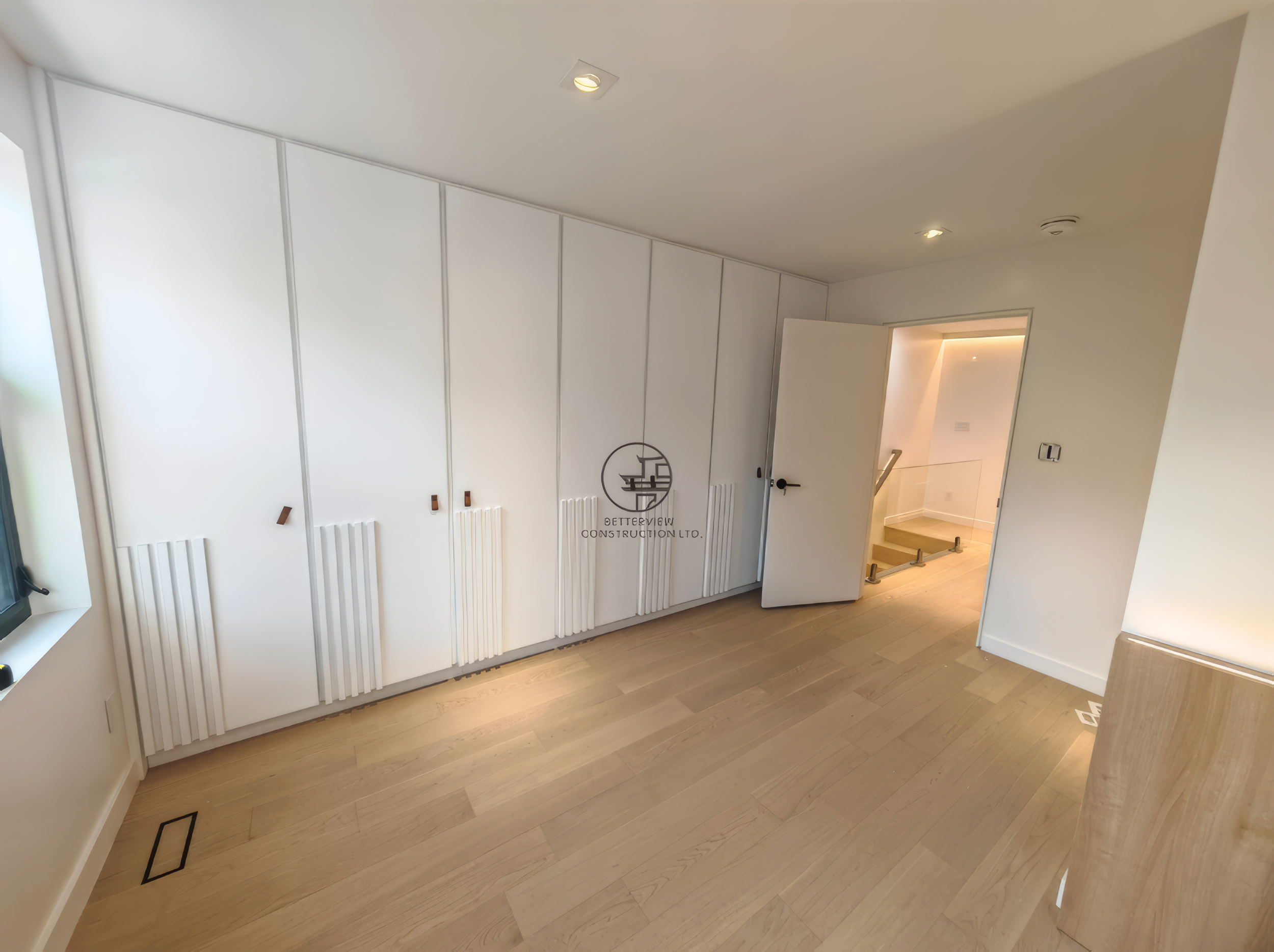 Bedroom renovation in Toronto featuring custom built-in closet, white cabinetry, and modern wood flooring
