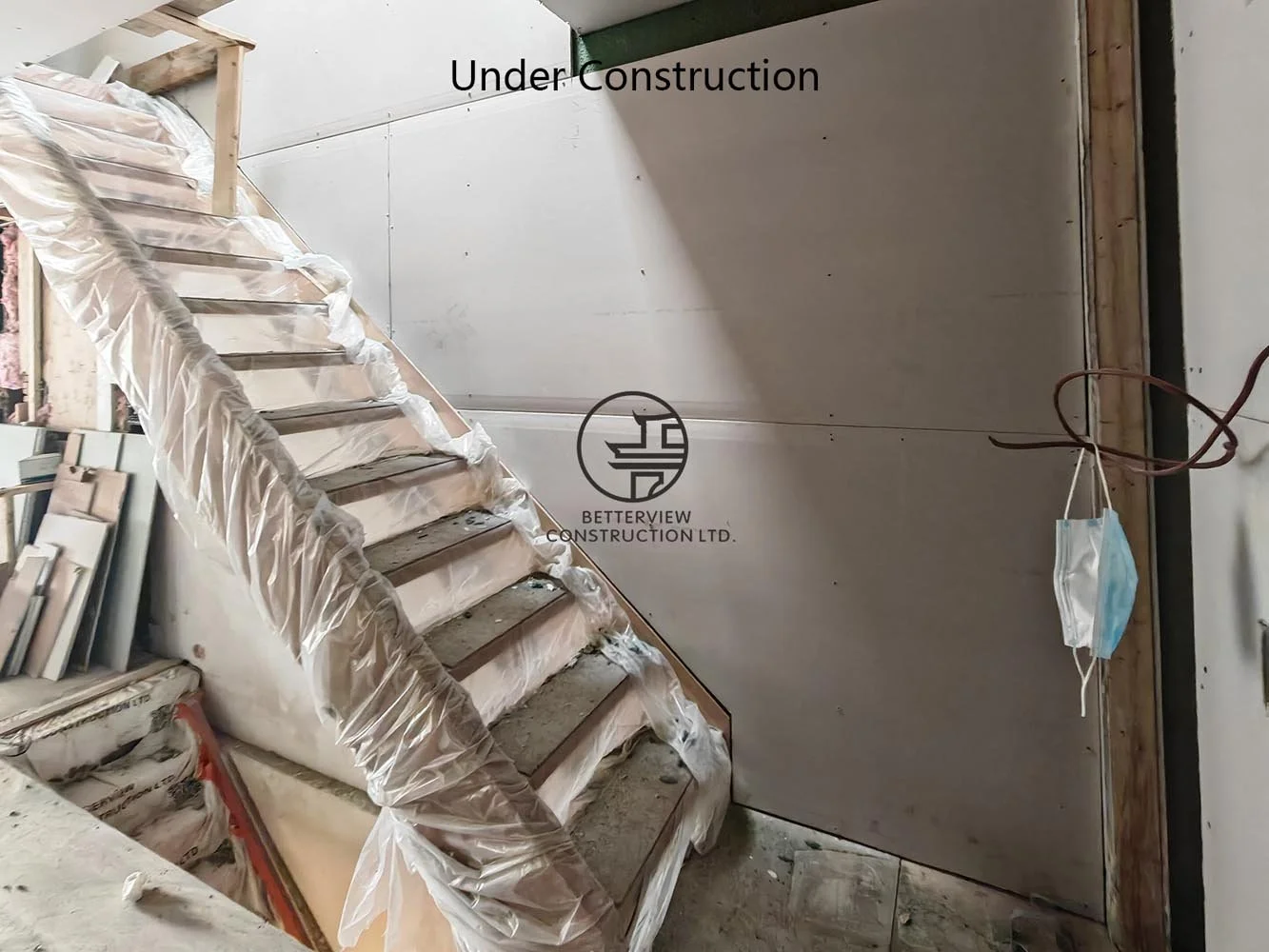 New staircase under construction connecting the redesigned interior after the complete layout reconfiguration and rear addition.