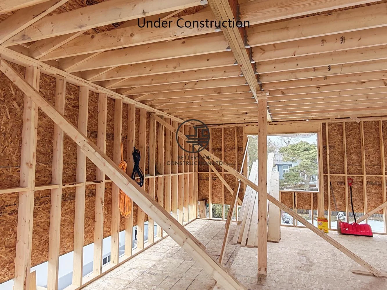 Structural framing for an open concept home addition featuring engineered beams, temporary supports, and spacious interior layout.