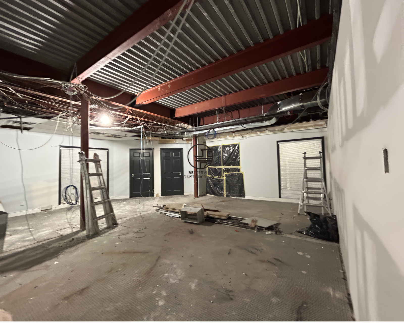 Commercial interior during structural demolition with exposed ceiling beams and wiring before renovation in Toronto