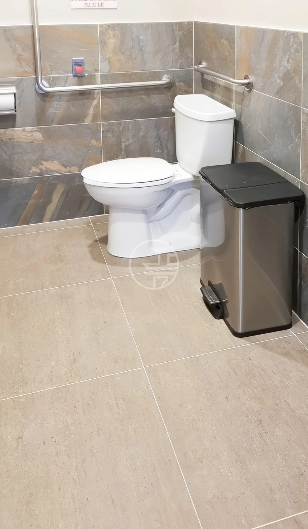 Accessible commercial washroom renovation in Toronto featuring ADA-compliant toilet, grab bars, and modern tile finishes