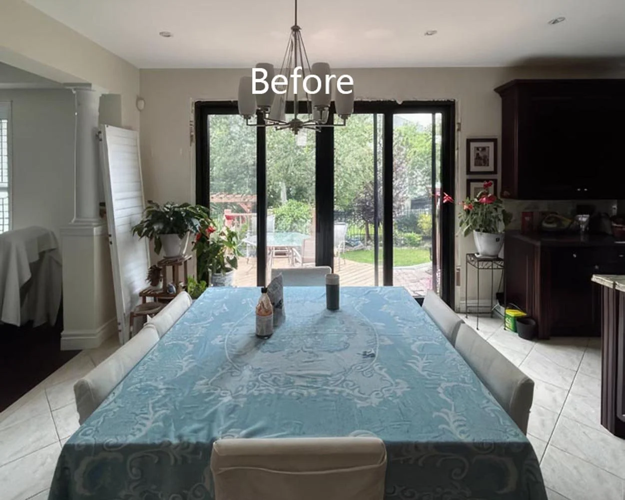 dining room before renovation with chandelier long table sliding glass doors and traditional layout in Toronto home interior