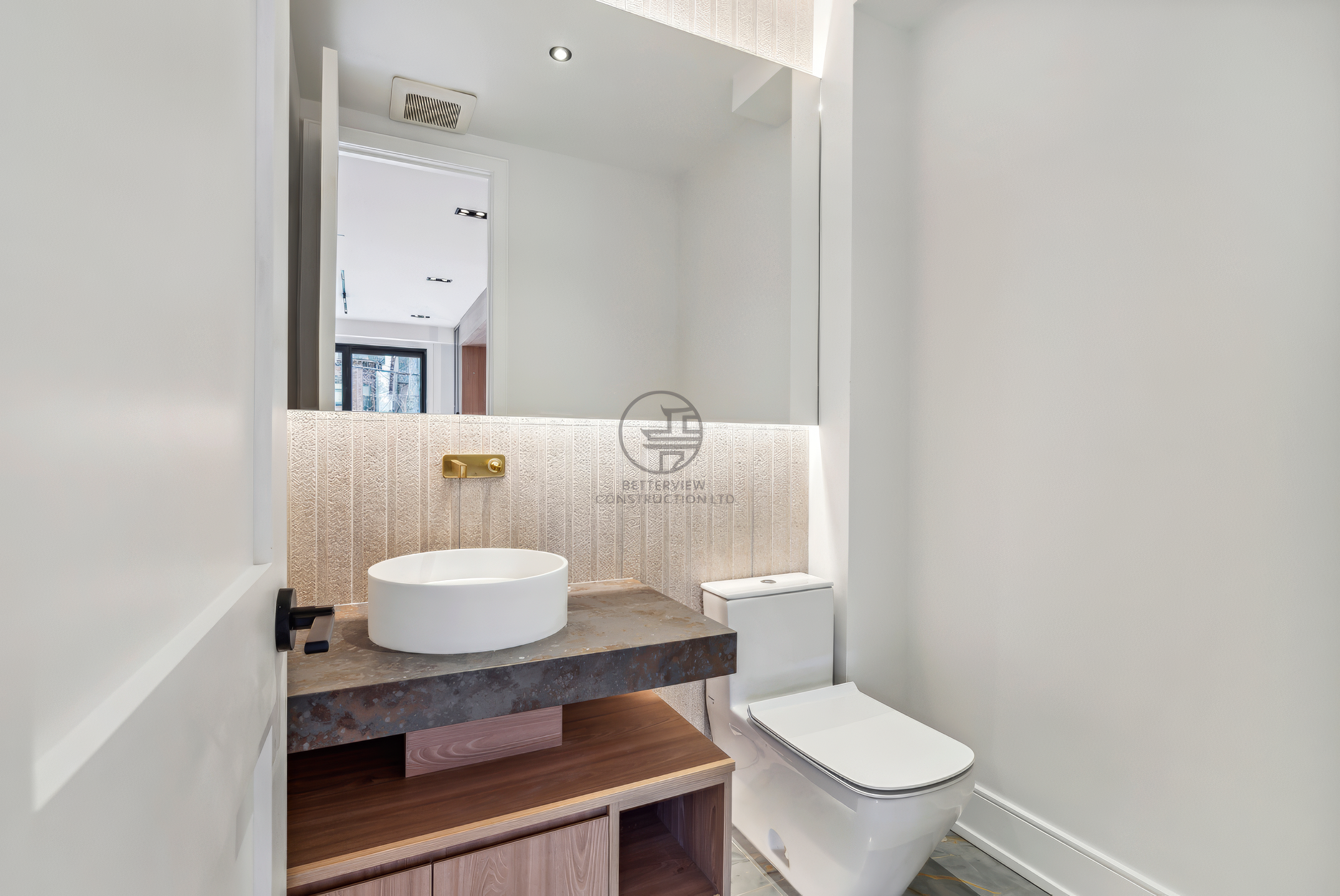 Modern powder room with vessel sink, wood vanity, LED backlit mirror, wall-mounted toilet, and minimalist contemporary design.
