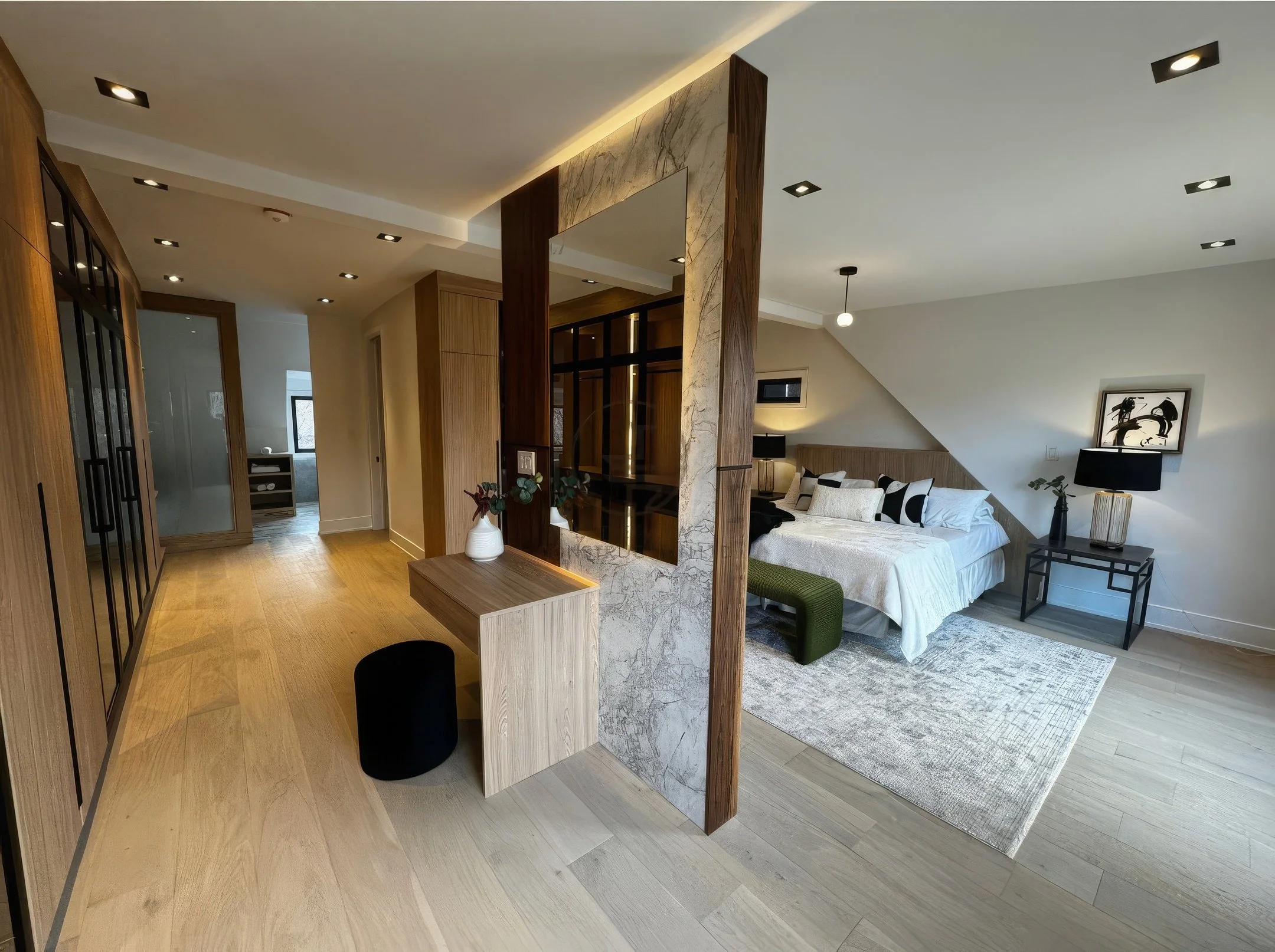 Modern bedroom with open-concept layout, wood panel partition, built-in vanity desk, and integrated shelving with warm ambient lighting.