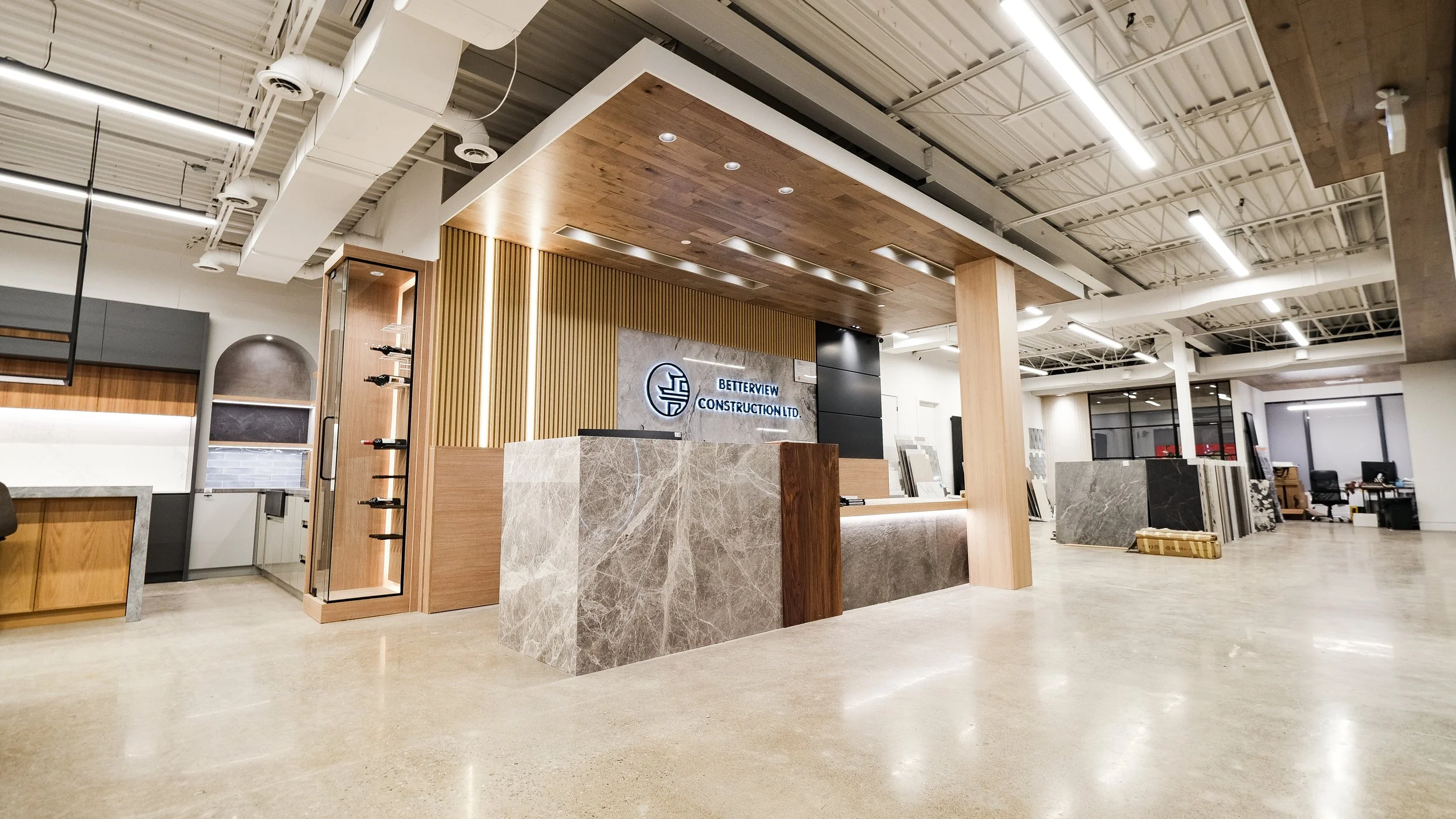 Betterview Construction showroom reception area with modern front desk, wood paneling, and commercial interior design in Toronto GTA