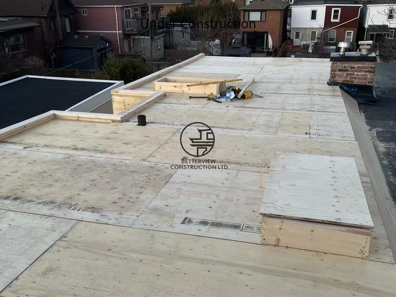 Roof construction in progress featuring structural roof decking and framing for the rear addition and cantilevered second floor.