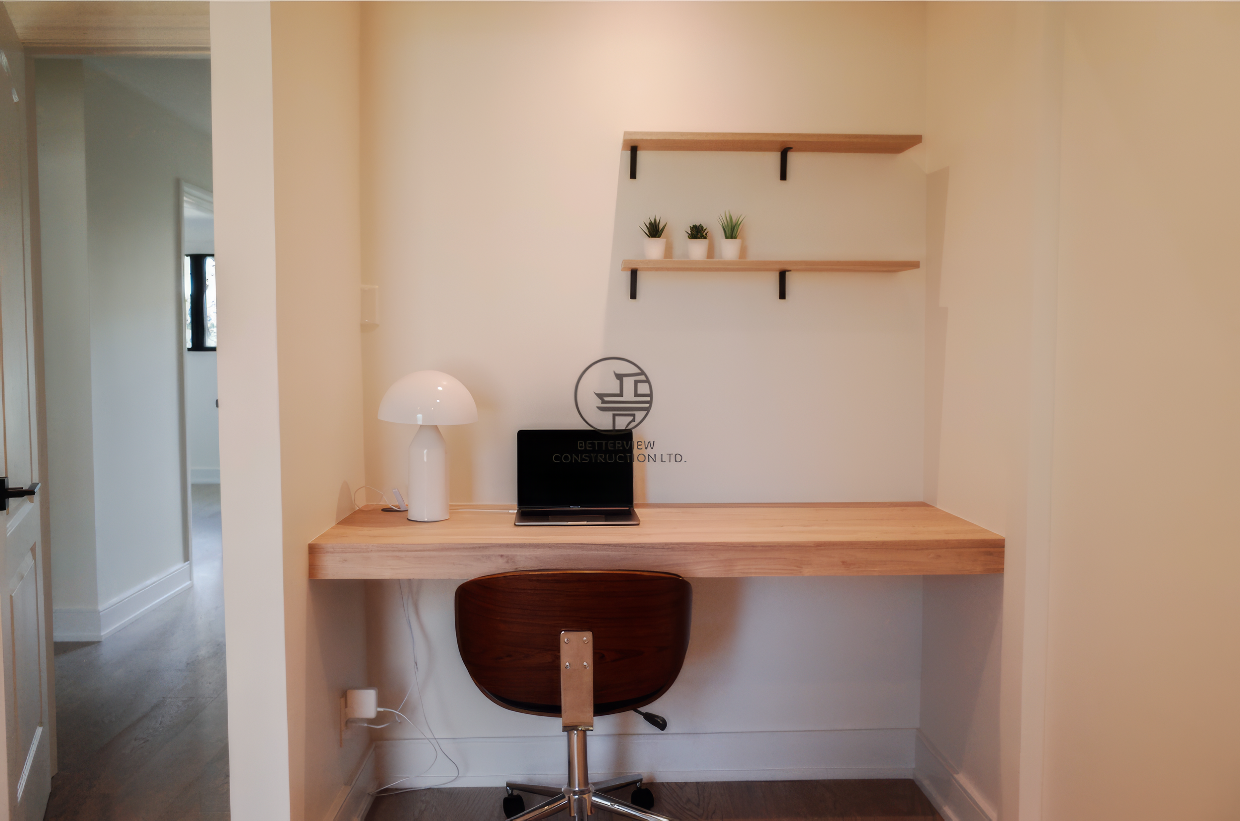 Modern home office nook with built-in desk, floating shelves, and minimalist workspace design in a Toronto home.
