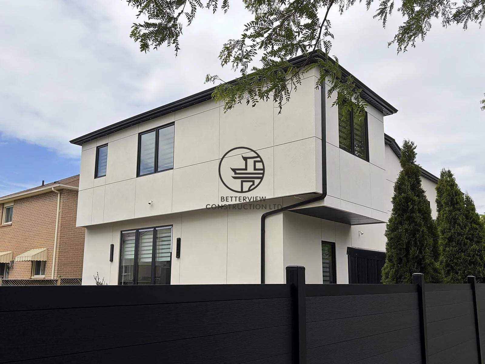 The rear corner of the addition highlights its minimalist architecture, large windows, and refined exterior details, seamlessly integrating new living space with the original home.