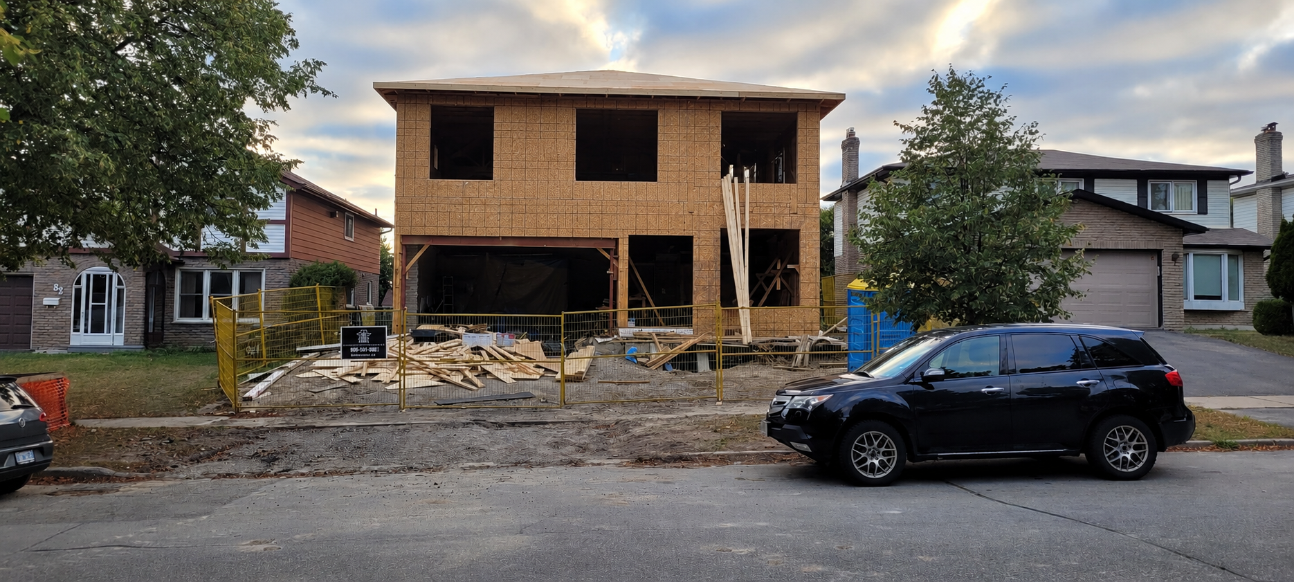 Over-the-garage addition under construction featuring new exterior framing, sheathing, and structural work before exterior finishes.