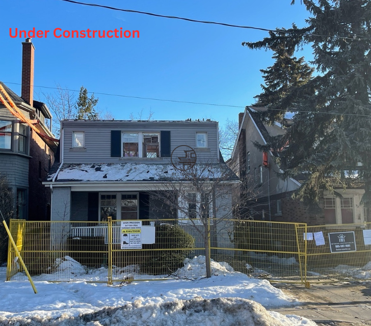 Exterior view of a residential home under construction with temporary fencing and active renovation work in the GTA