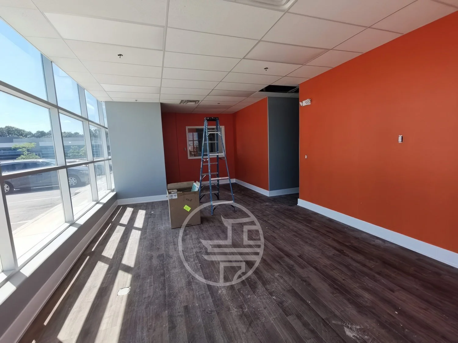 Commercial interior renovation in progress in Toronto featuring open retail space, flooring installation, and painted feature walls