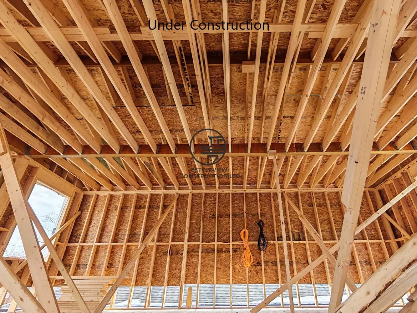 Exposed ceiling joists and floor framing during second floor home addition construction, demonstrating quality structural workmanship.