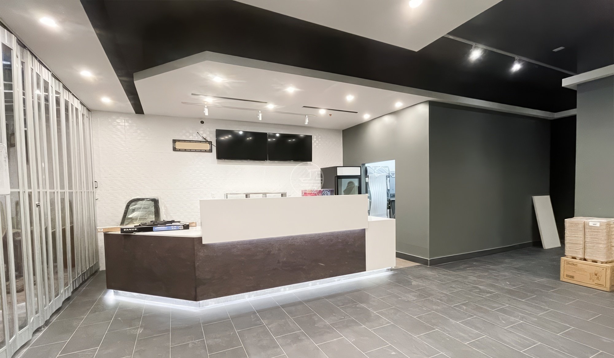 Modern commercial retail counter and reception desk renovation in Toronto featuring clean white surfaces, display screens, and contemporary interior design