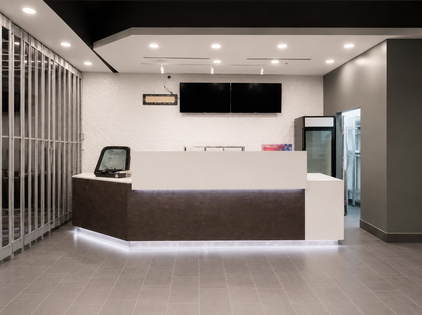 Modern commercial retail counter and reception desk renovation in Toronto featuring clean white surfaces, display screens, and contemporary interior design