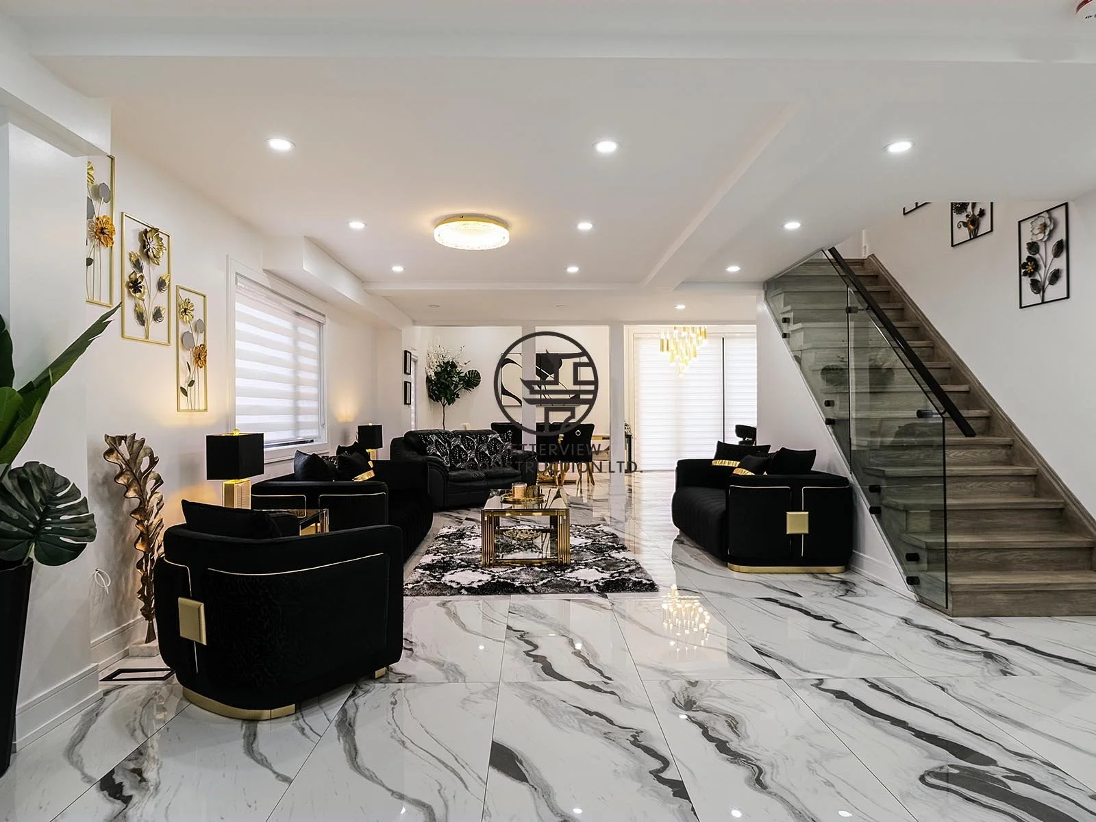 The open-concept living area features polished marble-look flooring, a modern glass staircase, and elegant finishes that create a bright, spacious, and welcoming environment.