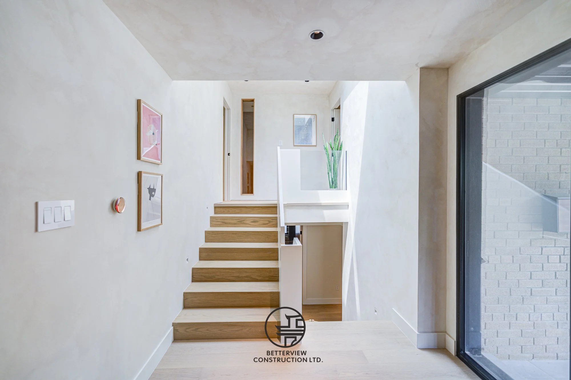 modern entryway with wood staircase in renovated Toronto home