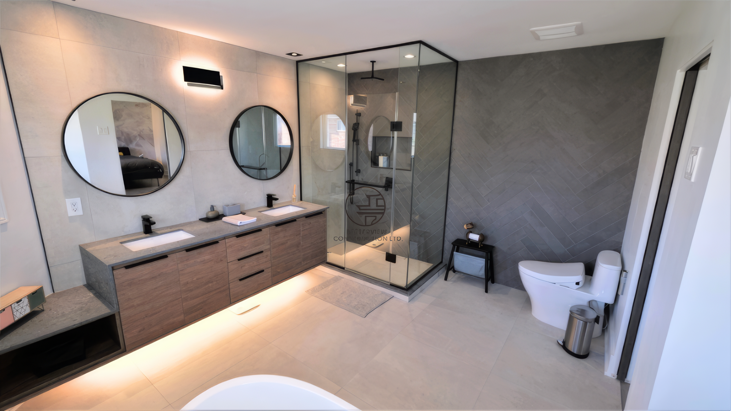 modern bathroom renovation with double vanity, glass shower, freestanding tub, and herringbone tile wall