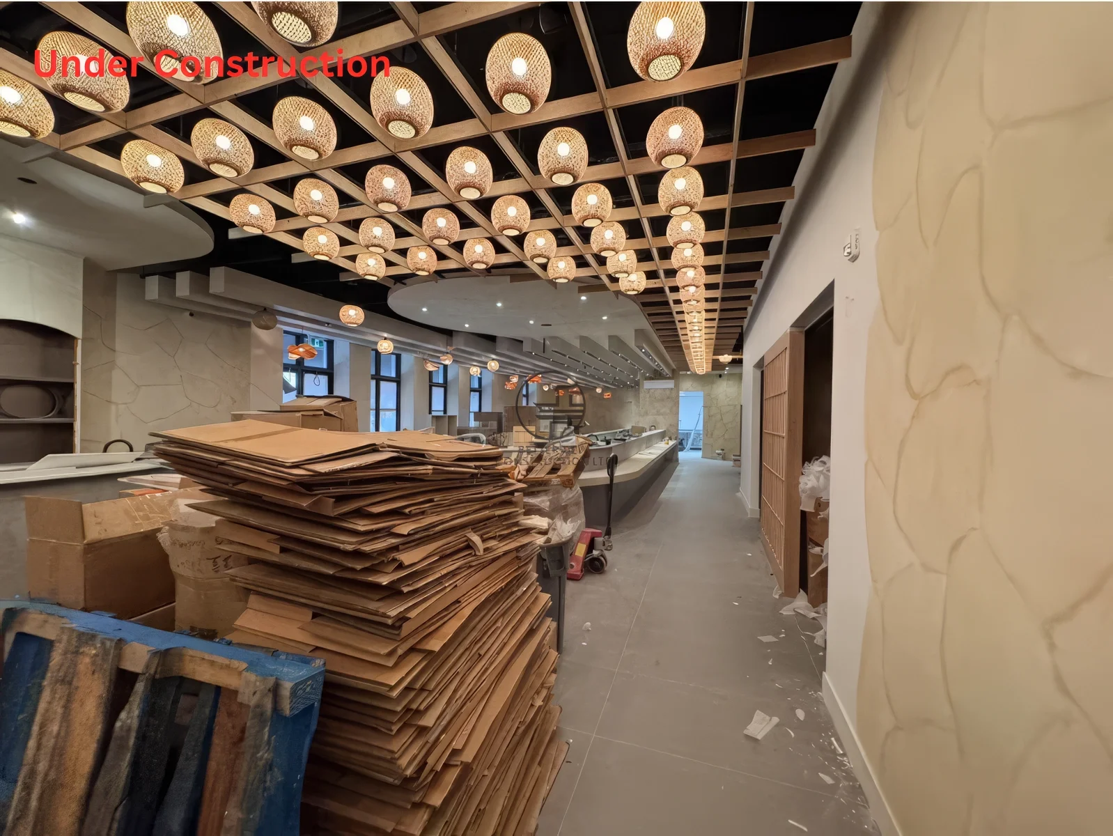 Restaurant renovation finishing phase in Toronto showing interior cleanup, completed ceiling lighting installation, and nearly finished dining layout
